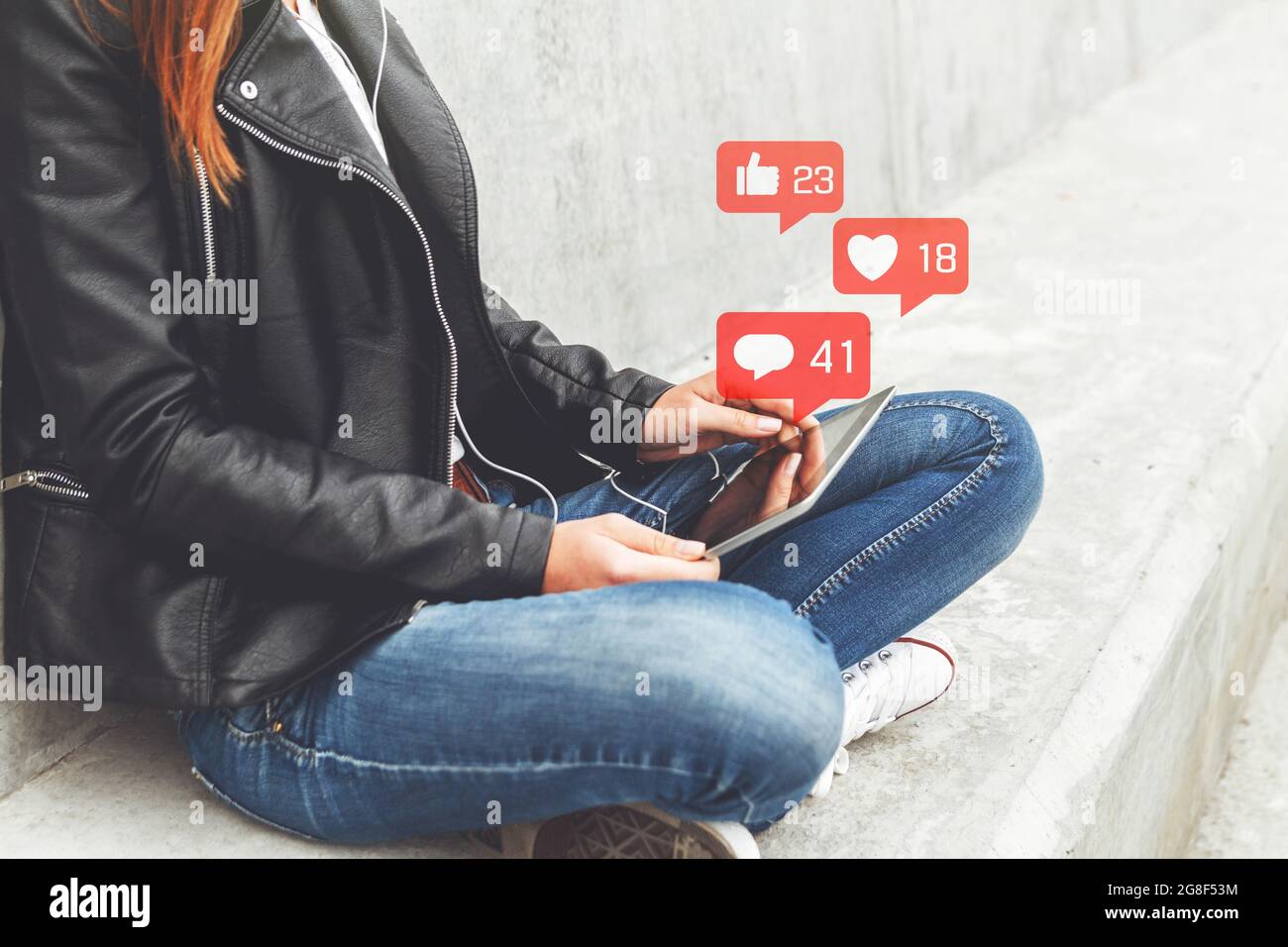 Giovane donna che utilizza un tablet digitale con notifica delle icone. Concetto di social media o social network. Foto Stock