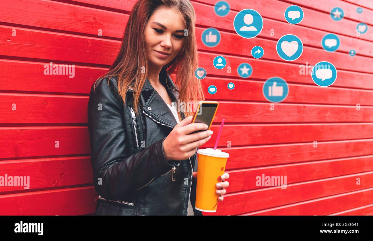 Giovane donna che utilizza lo smartphone con notifica delle icone. Concetto di social media o social network. Foto Stock