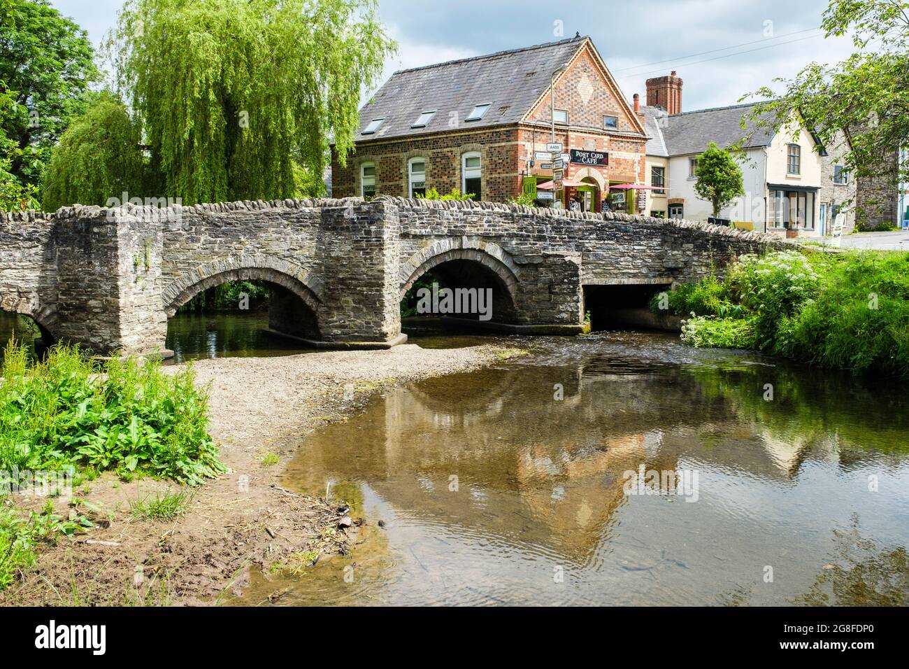 14thc vecchio ponte sul fiume Clun nel villaggio con Post Card caffè in Shropshire Hills Area di eccezionale bellezza naturale. Clun Shropshire Inghilterra Regno Unito Foto Stock
