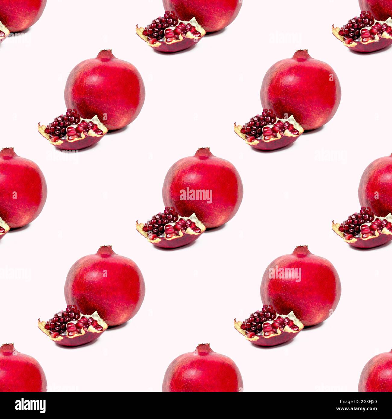 I pezzi in pomergranato rosso brillante ripetono un motivo senza cuciture su sfondo rosa chiaro. Foto Stock