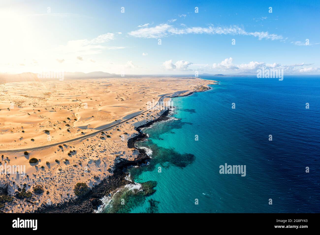 Vista aerea della strada vuota accanto al mare cristallino turchese e dune di sabbia, Corralejo, Fuerteventura, Isole Canarie, Spagna, Atlantico, Europa Foto Stock