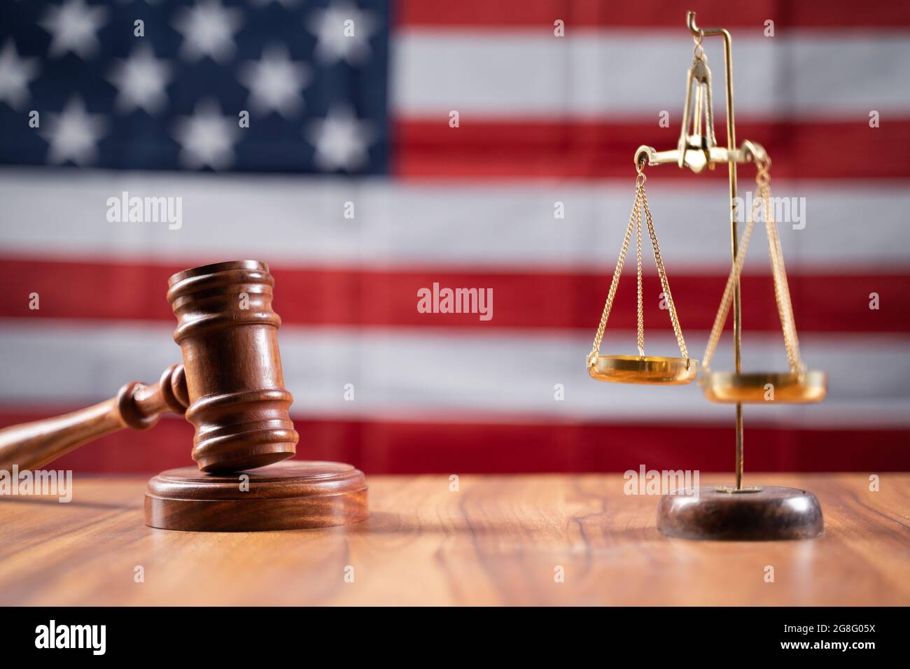 Concetto di Stati Uniti o sistema di giustizia americano mostrando utilizzando il giudice Gavel e bilancia bilancia sulla bandiera degli Stati Uniti come sfondo Foto Stock