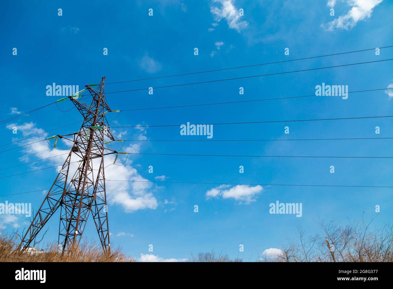 Linea elettrica aerea, linea di trasmissione di potenza, supporto di linea elettrica aerea ad alta tensione, sullo sfondo del cielo con le nuvole. Foto Stock