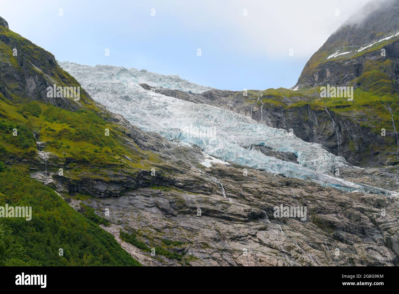 Dettaglio del Ghiacciaio Boyabreen che scorre lungo la montagna rocciosa. Paesaggio norvegese in un giorno d'estate. Foto Stock