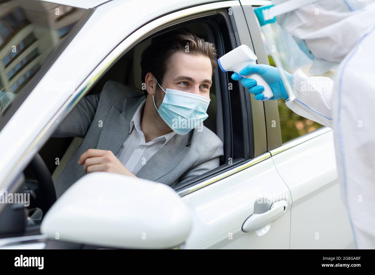 Operatori medici che misurano la temperatura con termometro all'esterno Foto Stock