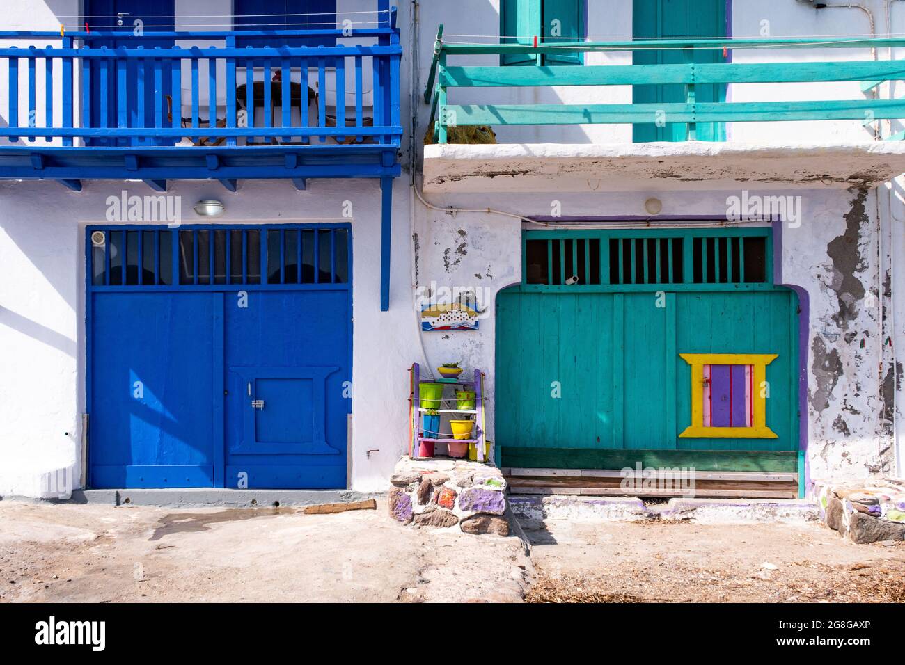 Colorate porte di garage blu e verde nel villaggio di pescatori greco Klima - il villaggio più colorato della Grecia, con vasi colorati, balconi e tradizionali Foto Stock