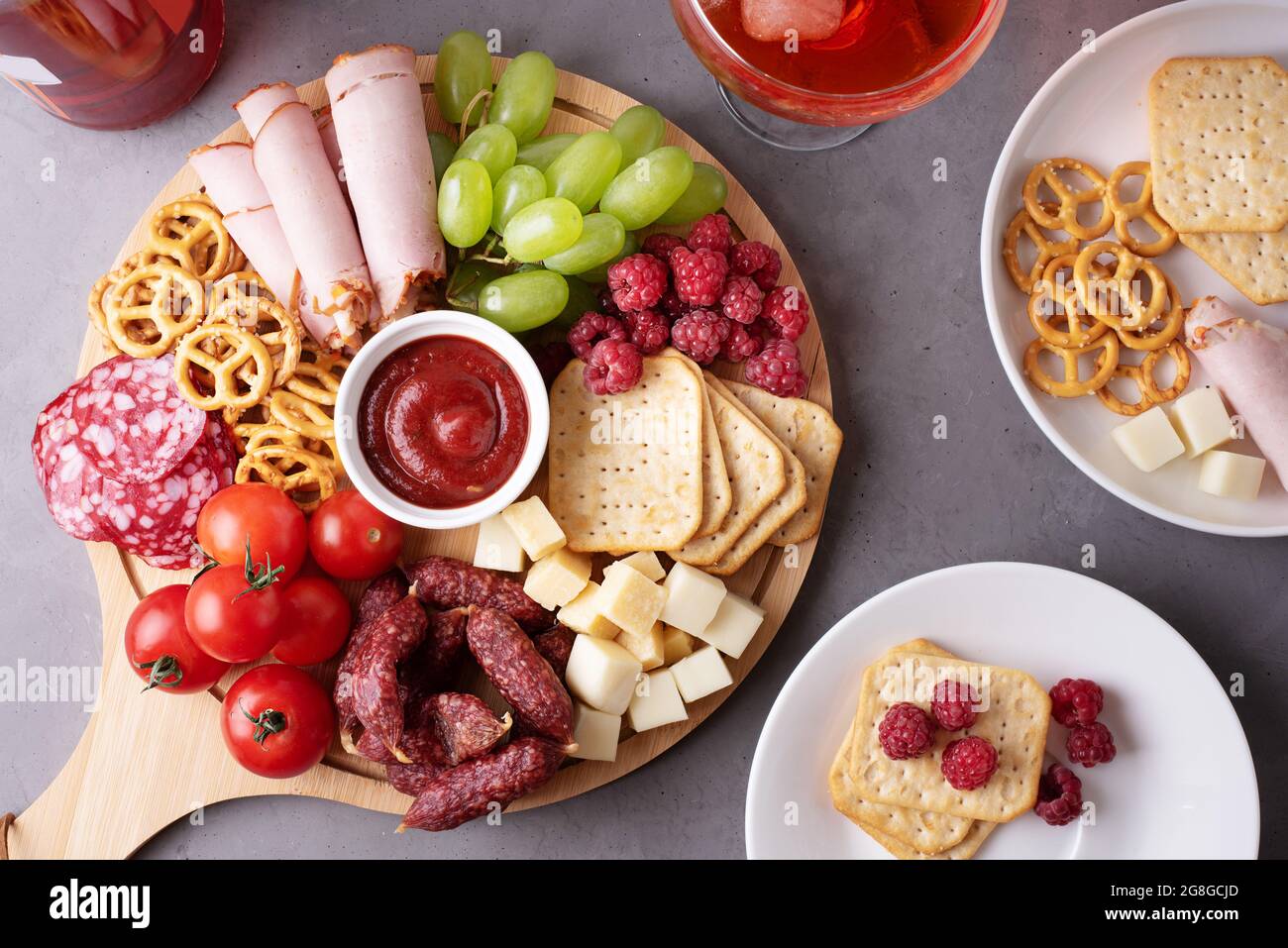 Una tavola rotonda di salumi con salsiccia, formaggio, cracker e frutta,  piatti con antipasto, primo piano Foto stock - Alamy