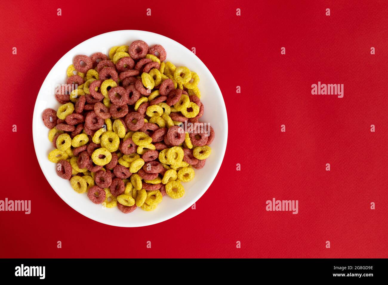 ciotola di cheerios di cereali isolata su sfondo rosso, colazione di cheerios di grano intero, mangiare sano Foto Stock