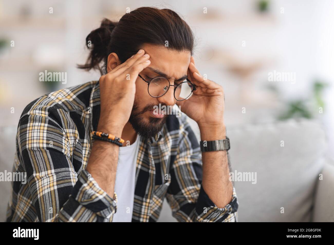 Closeup di triste ragazzo arabo che tocca la testa Foto Stock