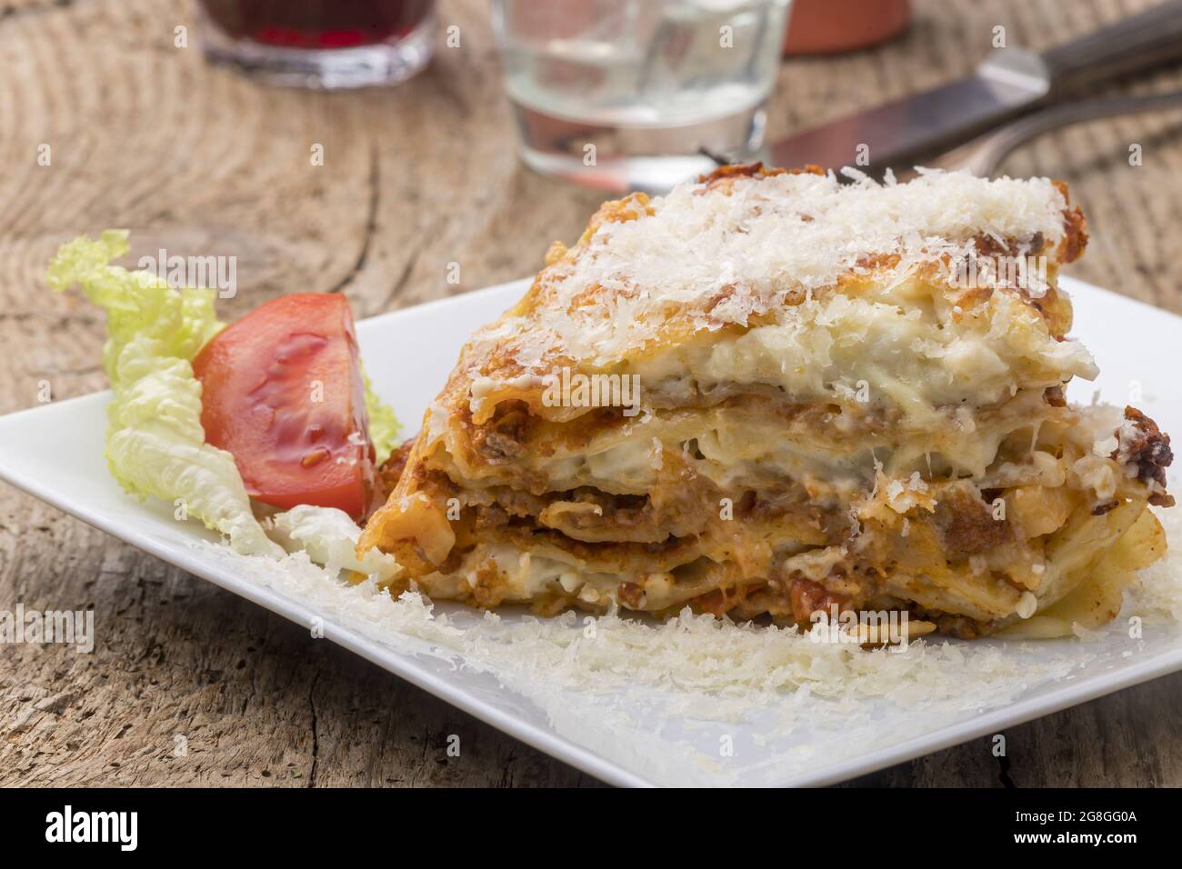 porzione di lasagna su un piatto bianco Foto Stock