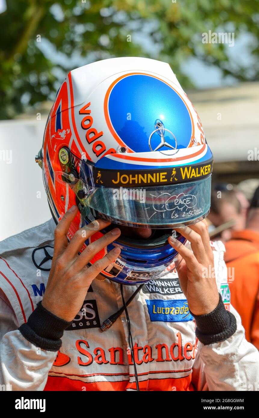 Jenson Button si prepara a correre una classica vettura da corsa McLaren all'evento Goodwood Festival of Speed, nel Regno Unito. Indossare il casco, con la visiera staccabile Foto Stock