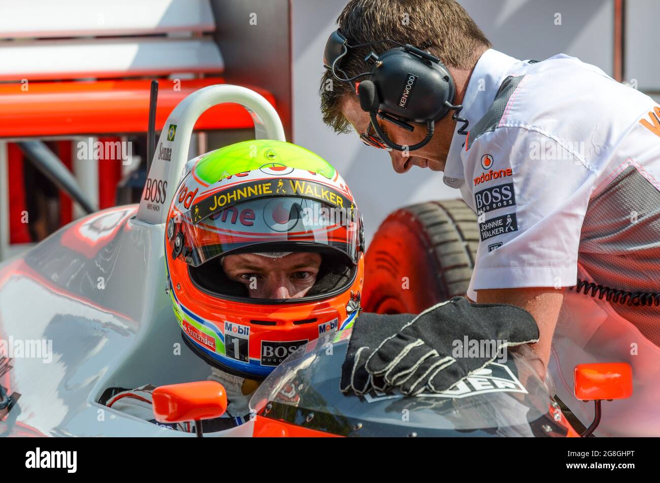 Oliver Turvey, pilota di corse, si prepara a correre la storica McLaren MP4/4 di Ayrton Senna all'evento Goodwood Festival of Speed. Con il membro del team Foto Stock