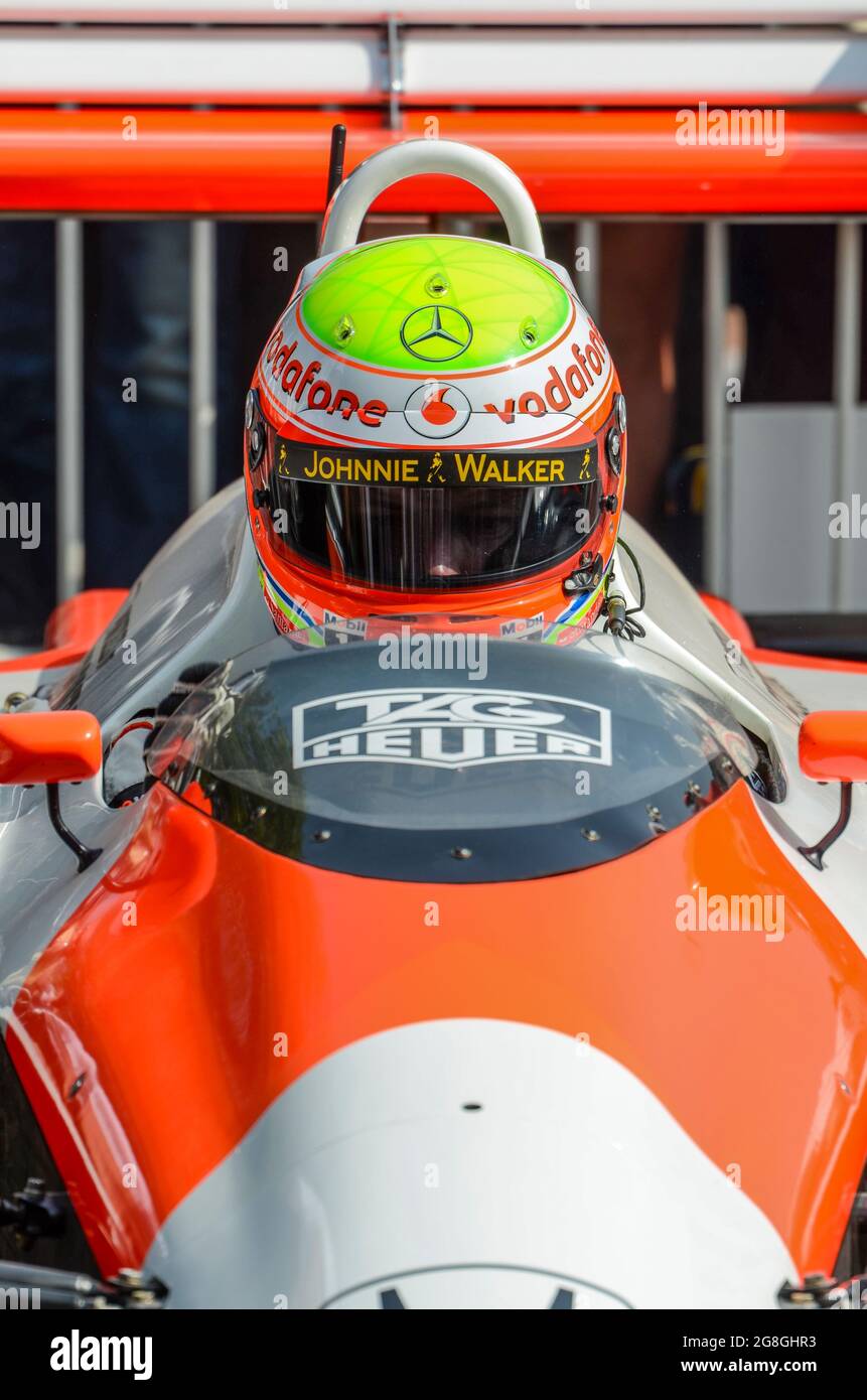 Oliver Turvey, pilota di corse, si prepara a correre la storica McLaren MP4/4 di Ayrton Senna all'evento Goodwood Festival of Speed, UK. Visiera dell'elmetto abbassata Foto Stock