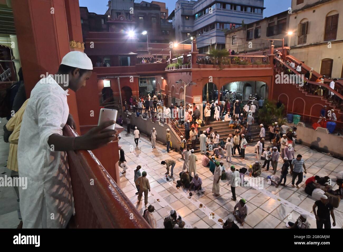 KOLKATA, BENGALA OCCIDENTALE, INDIA - MAGGIO 27 2019 : giovane ragazzo musulmano che prende selfie mentre i devoti musulmani stanno rompendo il loro digiuno lungo di giorno avendo cibo un Foto Stock