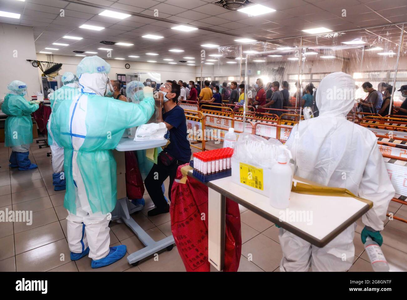 Gli operatori sanitari hanno visto indossare indumenti di protezione individuale (PPE) mentre aspettano che le persone prendano il test Covid-19. La CDC di Taiwan ha annunciato nuove linee guida per alleviare le restrizioni pandemiche. Foto Stock