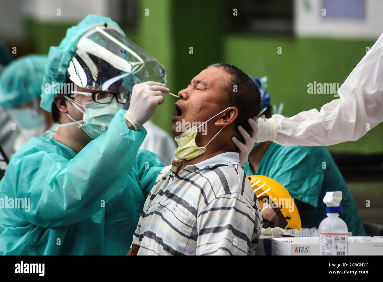 Un operatore sanitario preleva un campione di tampone nasale da un uomo durante il test di Covid-19. La CDC di Taiwan ha annunciato nuove linee guida per alleviare le restrizioni pandemiche. Foto Stock