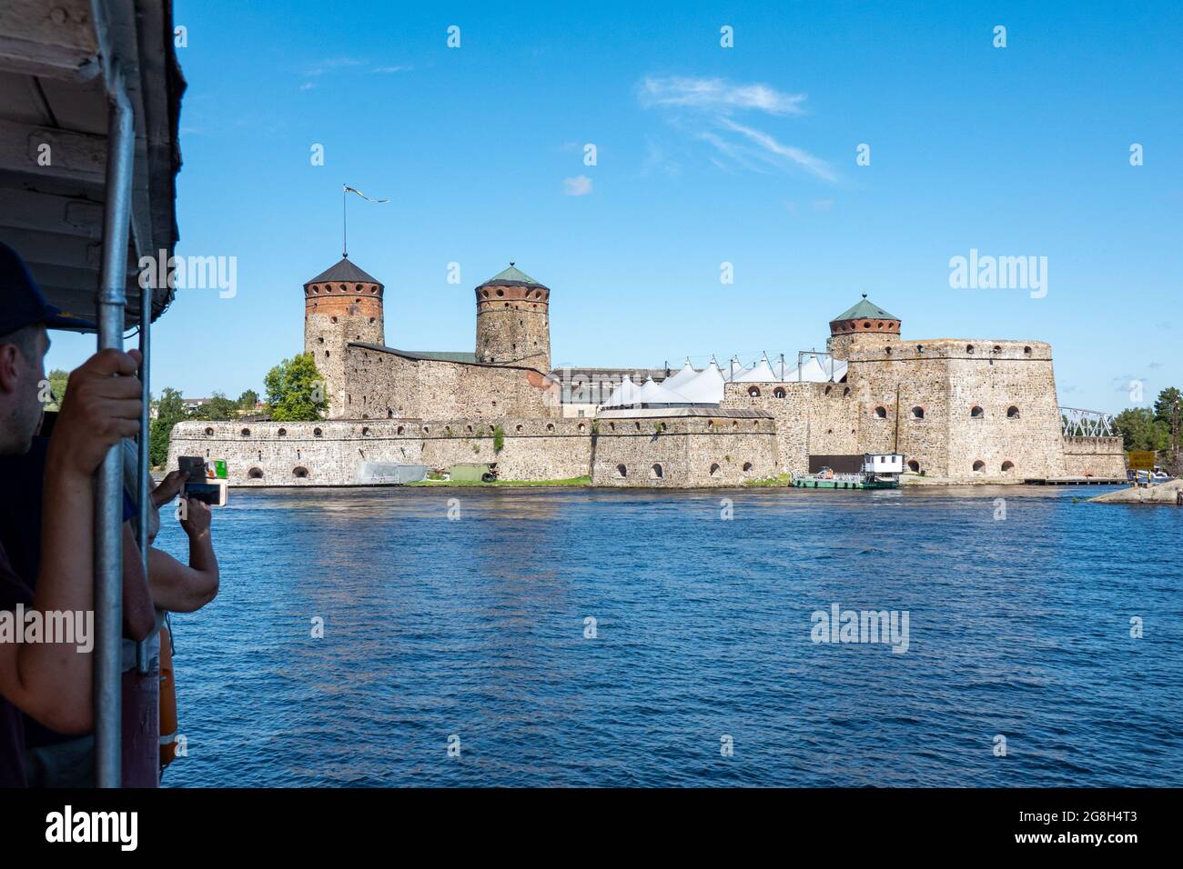 I turisti in crociera sul lago Saimaa scattano foto della fortezza medievale in pietra di Olavinlinna, sede del Festival dell'Opera di Savonlinna, a Savonlinna, Finlandia Foto Stock