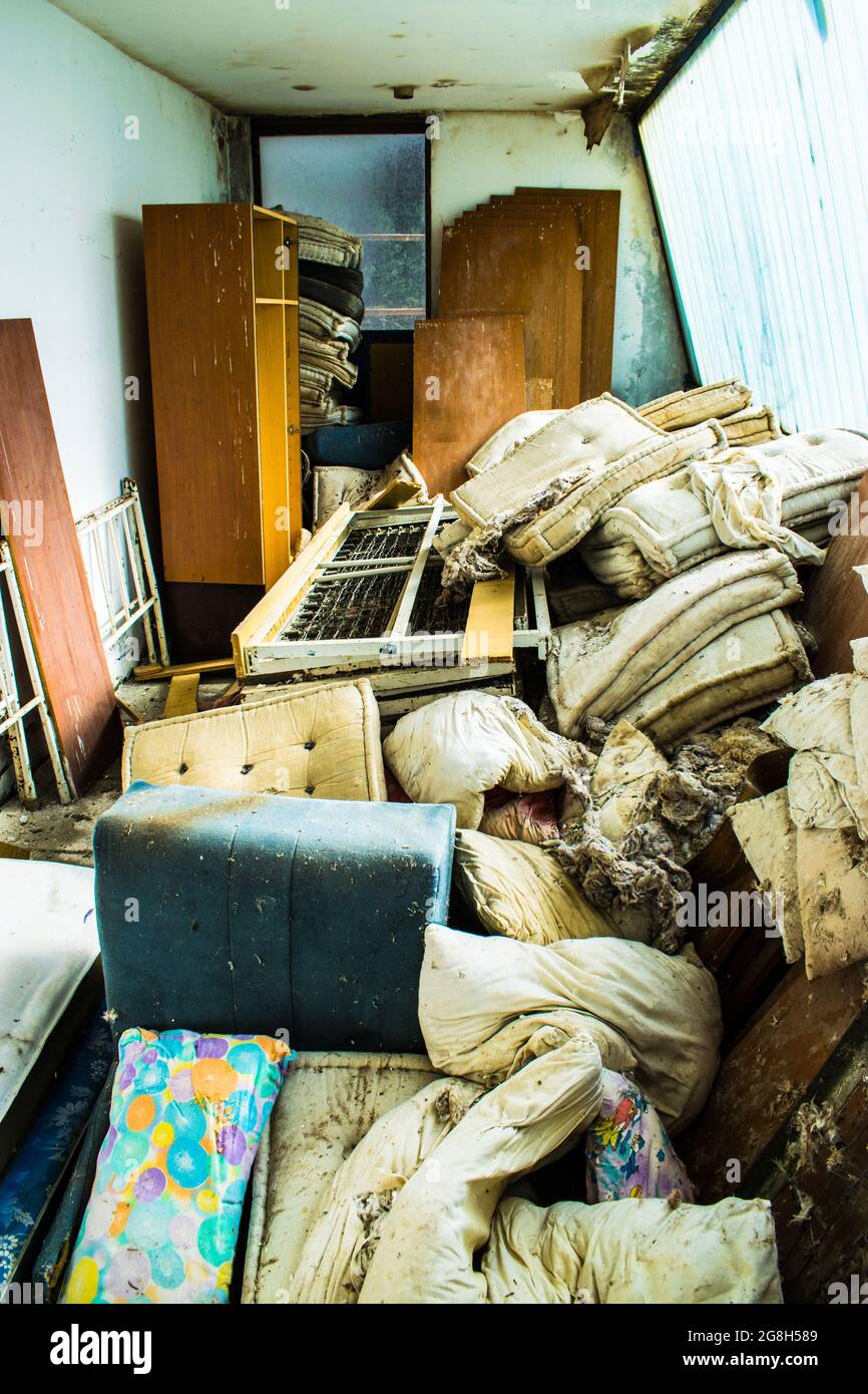 Camera piena di mobili antichi guardaroba letti materassi spazzatura Foto Stock