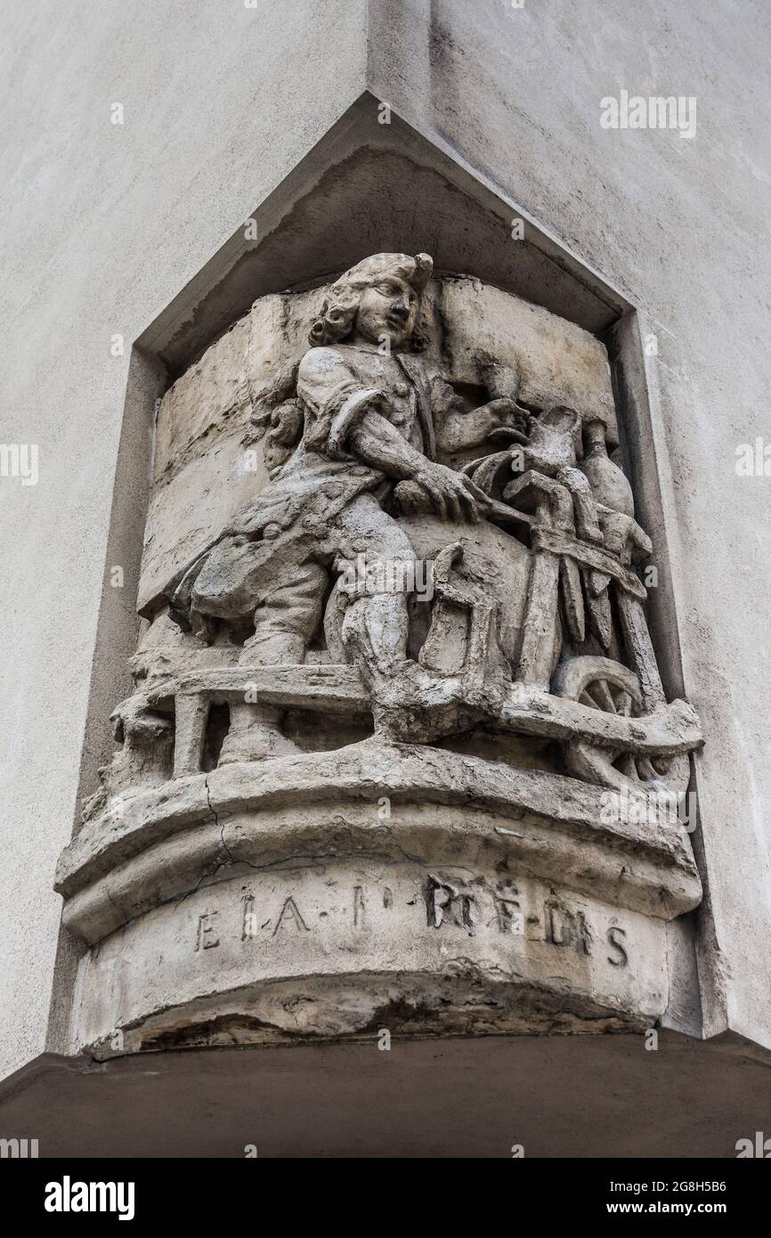 Antica scultura in pietra sull'angolo di strada parigino raffigurante una ruota di vasaio e vasaio - Parigi, Francia. Foto Stock