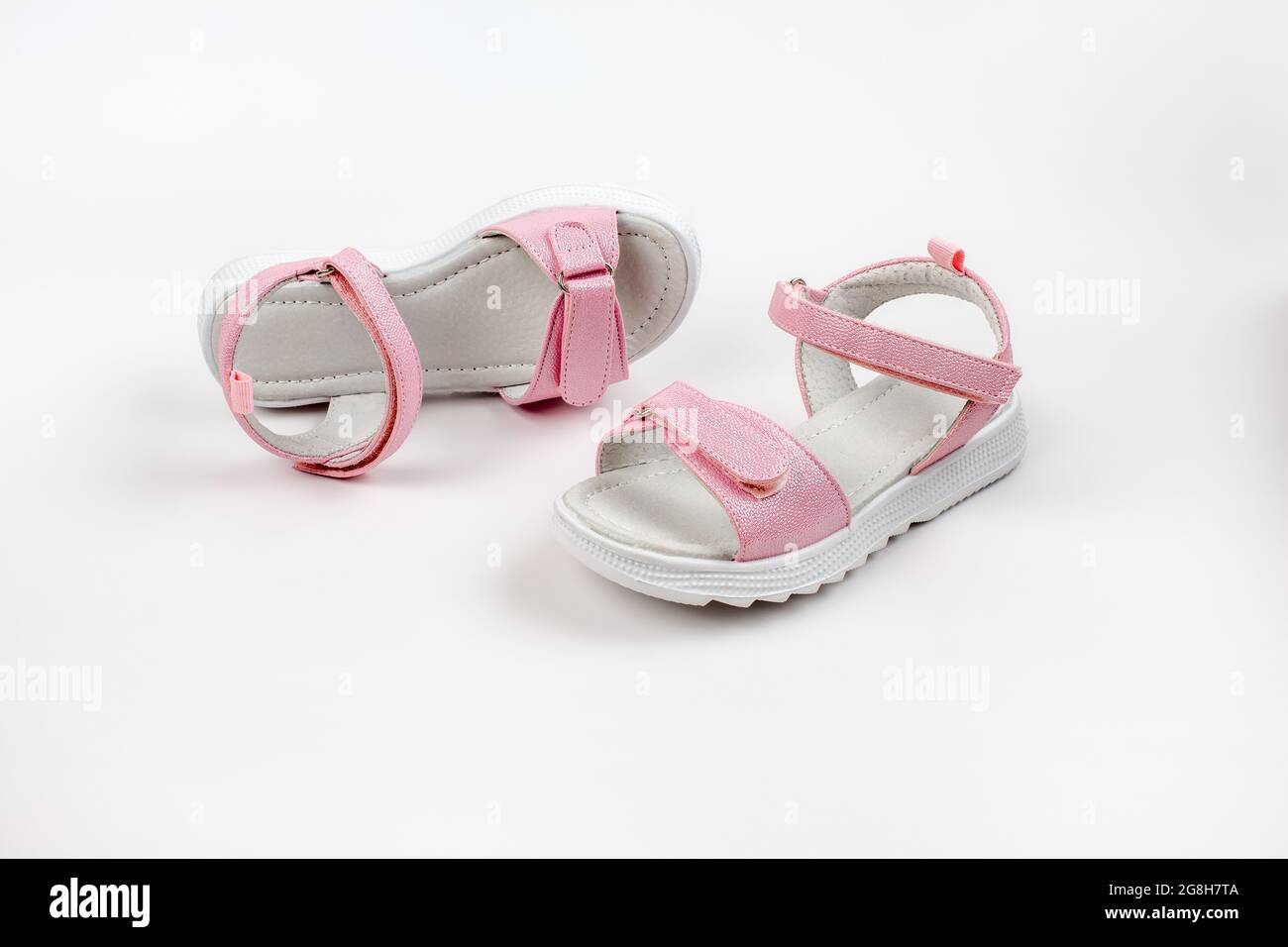 Sandali rosa isolati. Sandali rosa per bambini con suole bianche e chiusure in velcro isolate su sfondo bianco. Scarpe per bambini alla moda per Foto Stock