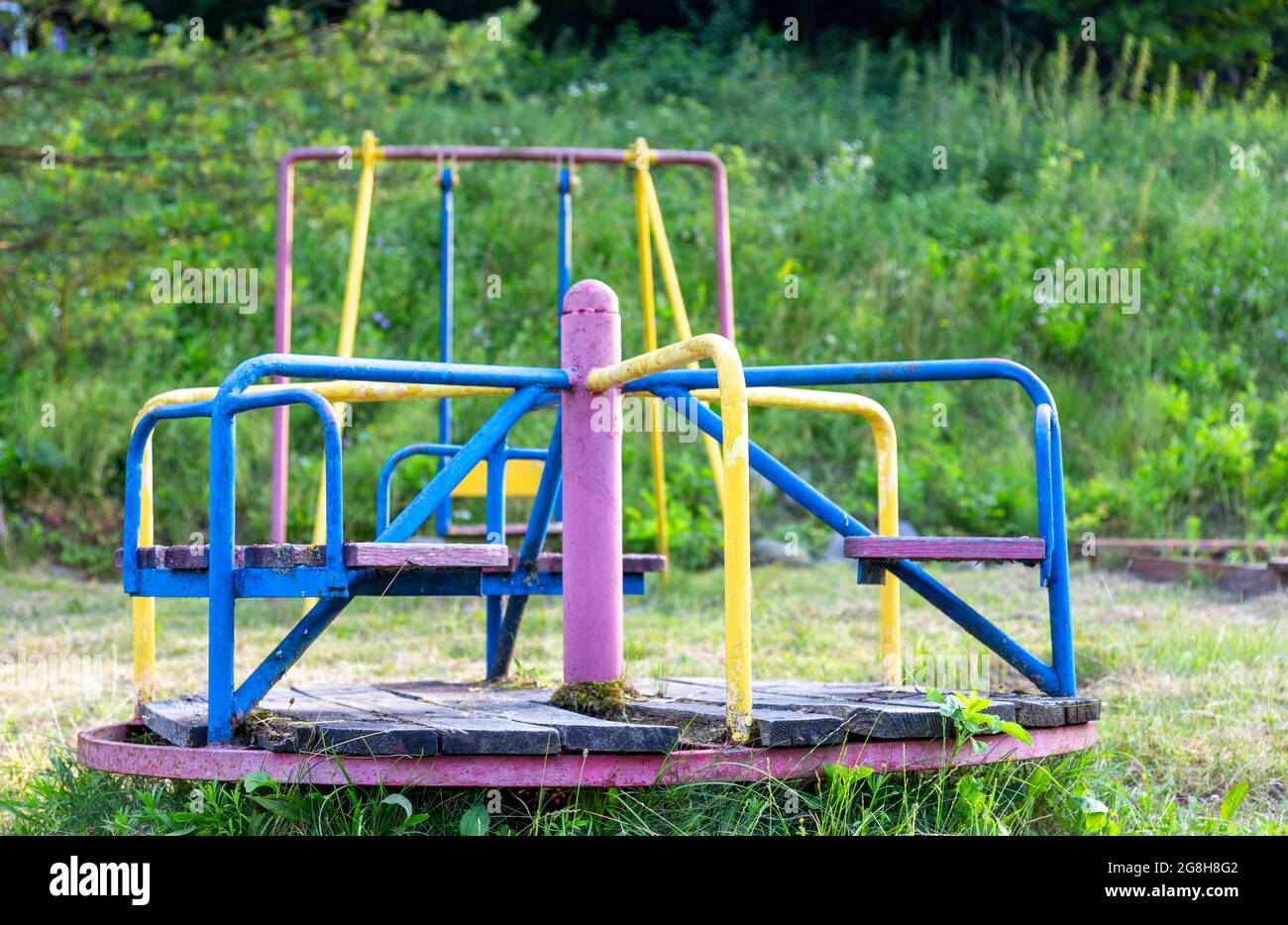 Parco giochi abbandonato. Giostra arrugginita non funzionante. Giochi per bambini. Foto Stock