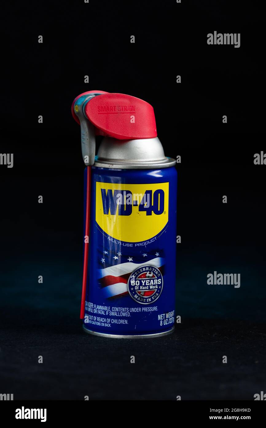 Bomboletta spray multi-lubrificante WD-40 comunemente utilizzata in azienda e a casa per una varietà di impieghi su fondo scuro Foto Stock