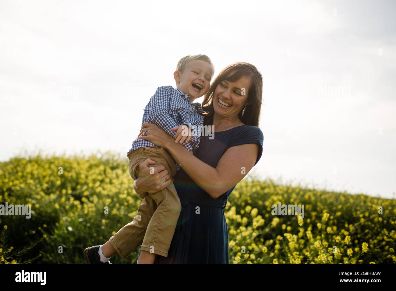 Madre & Figlio Laughing nel Wildflower Field Foto Stock