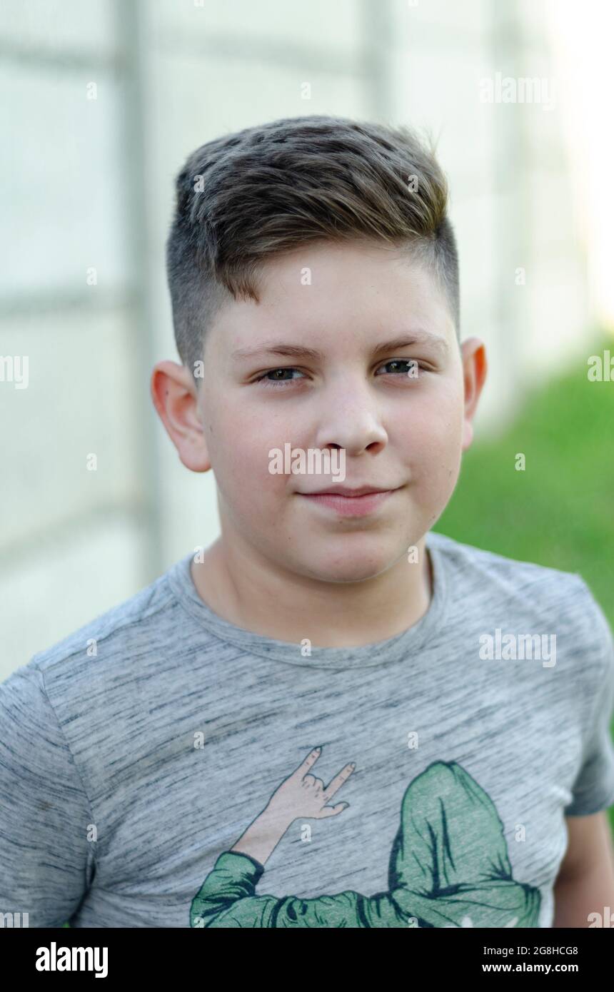 ritratto di un ragazzo di 11 anni su sfondo grigio Foto Stock