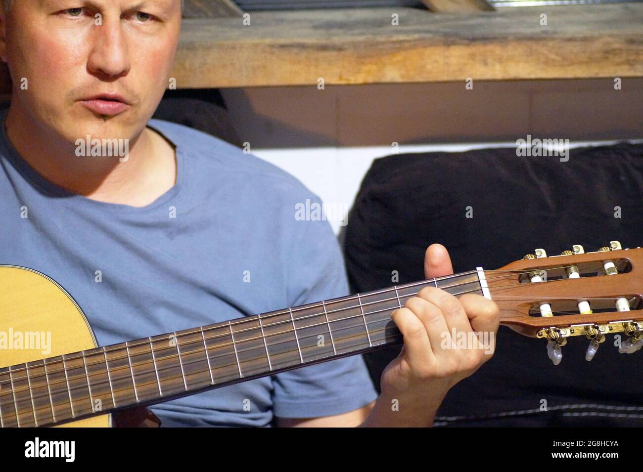 Un uomo di 45 anni suona la chitarra Foto Stock
