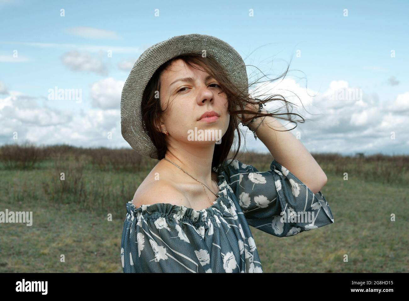Ritratto di una ragazza in un cappello sul campo, guardando la macchina fotografica. Foto Stock
