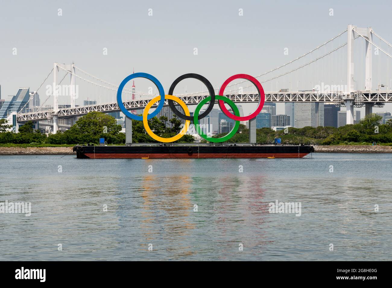 Gli anelli olimpici galleggiano da Odaiba con il Ponte dell'Arcobaleno alle spalle. 2020 / 2021 Tokyo, Giappone Foto Stock