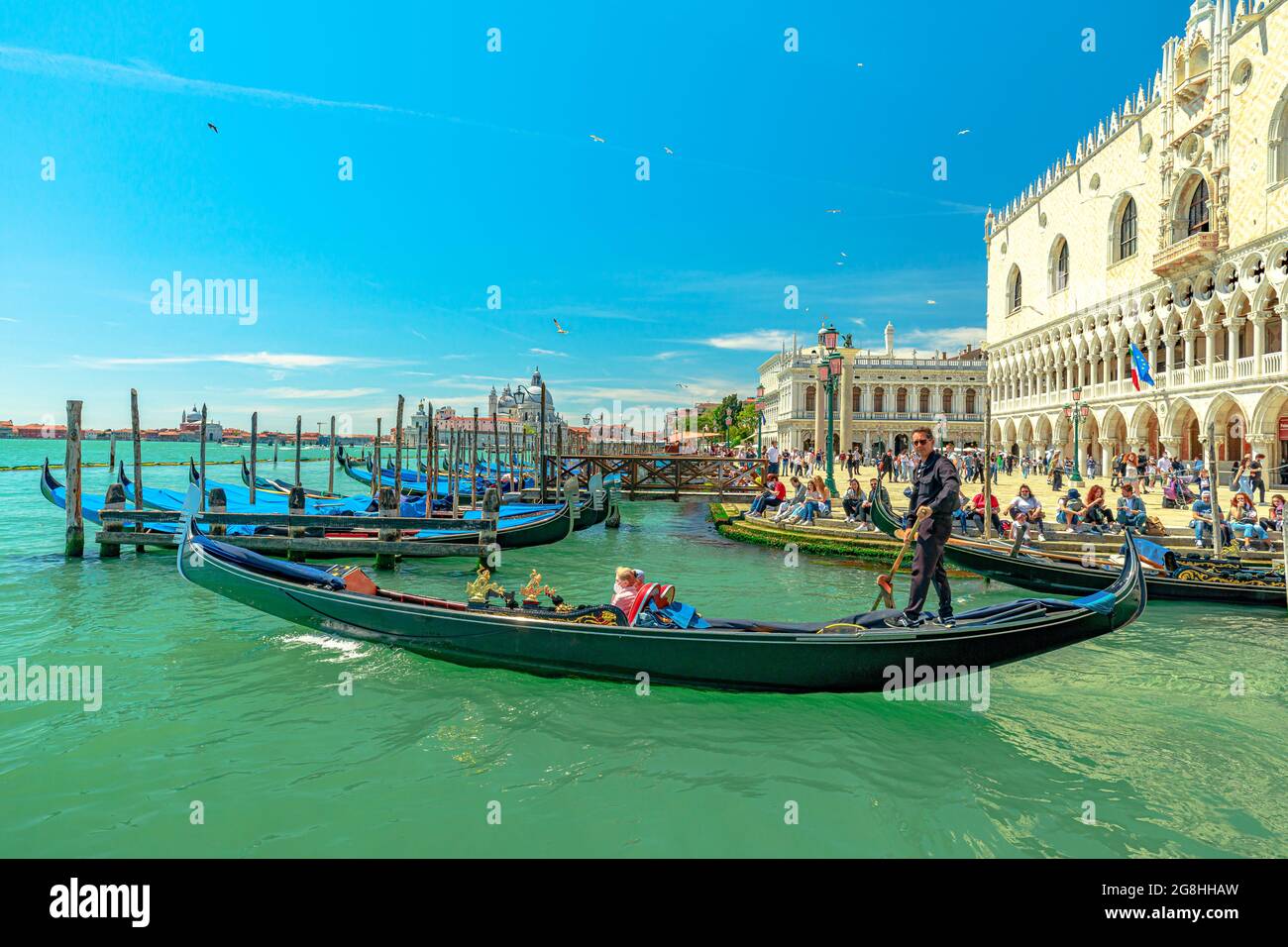 Venezia, Italia - 9 maggio 2021: Servizio di gondola tradizionale con i turisti in tour sul Canal Grande in Piazza San Marco. Il canale più grande di Venezia Foto Stock