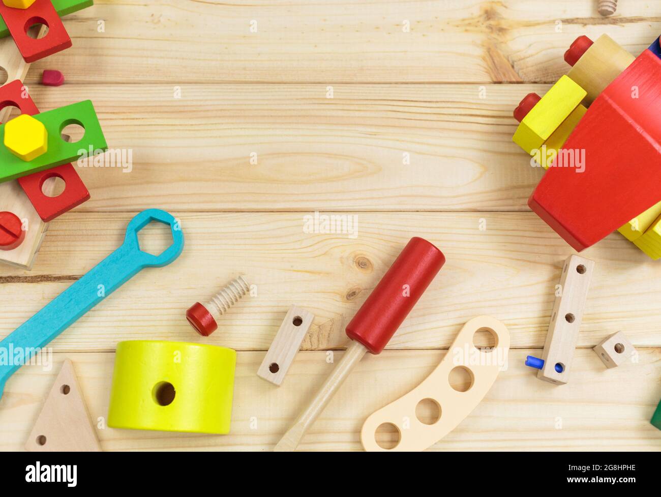 Un colorato kit da costruzione in legno per bambini su legno. Set di attrezzi su tavolo di legno. Giochi e strumenti per i bambini in età prescolare o in asilo. Naturale, eco-patatine Foto Stock