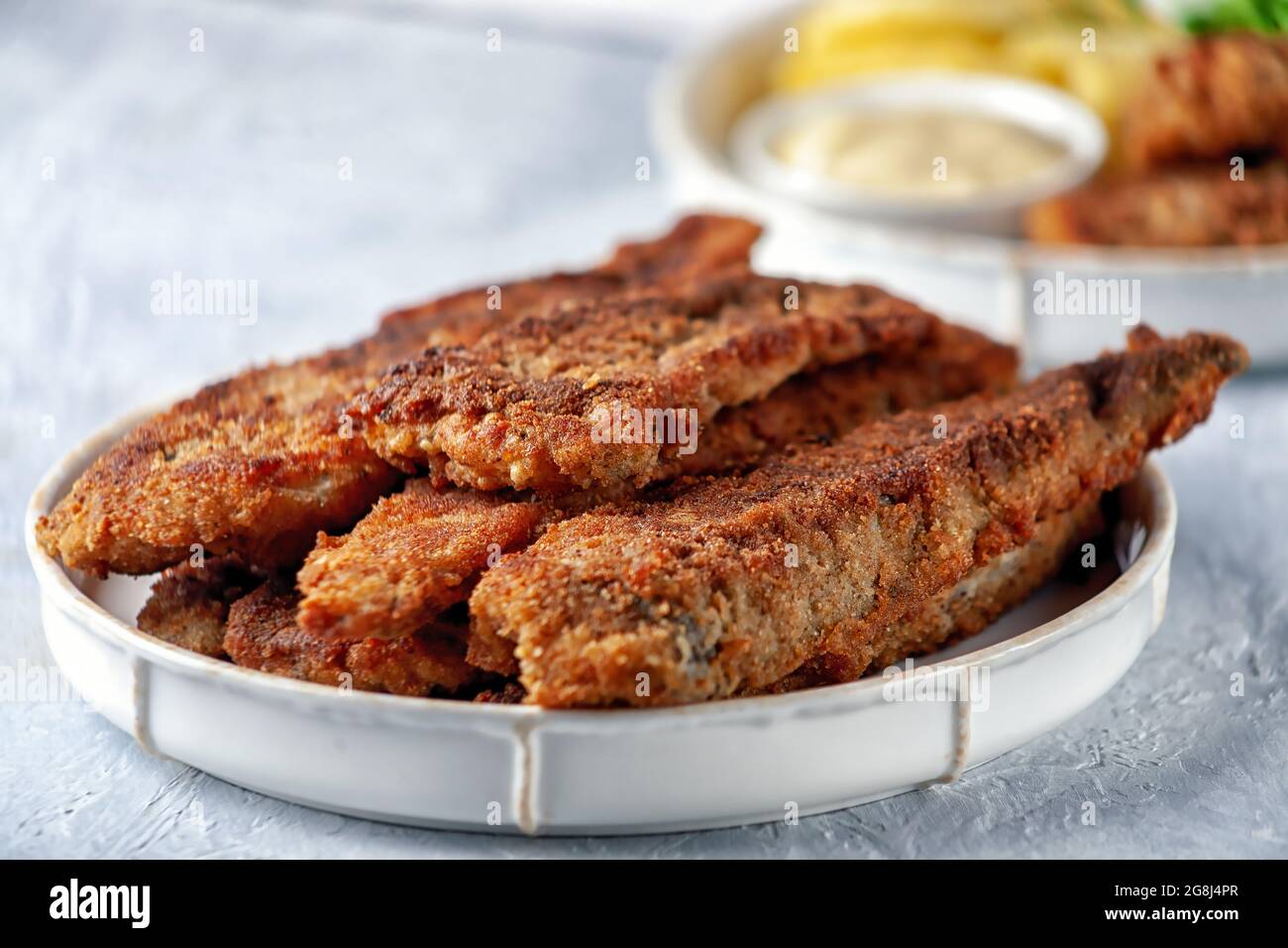 Pesce fritto con piselli verdi, limone e patate fritte Foto Stock