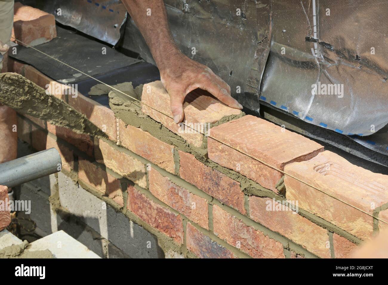 Primo piano di mattoni in fase di costruzione della parete esterna di un nuovo bungalow a Surrey, Regno Unito Foto Stock