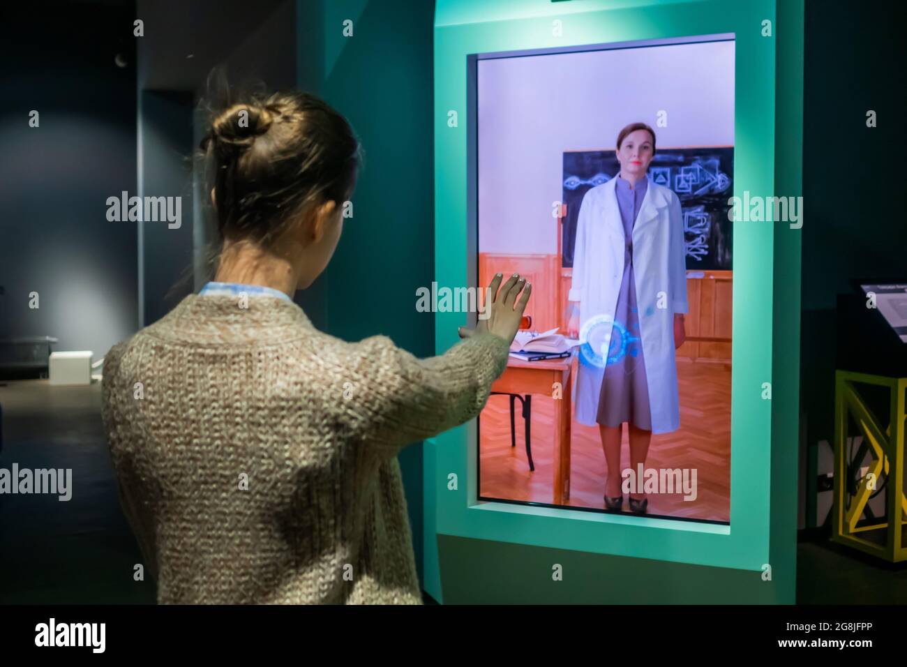 Donna che utilizza interactive touchless chiosco di visualizzazione senza toccare la tecnologia di controllo Foto Stock