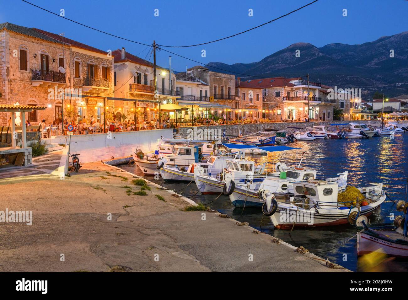 Guardando attraverso il porto nel piccolo villaggio di pescatori di Ayios Nikolaos su una notte d'estate. Nella parte esterna di Mani, sud del Peloponneso, della Grecia. Foto Stock