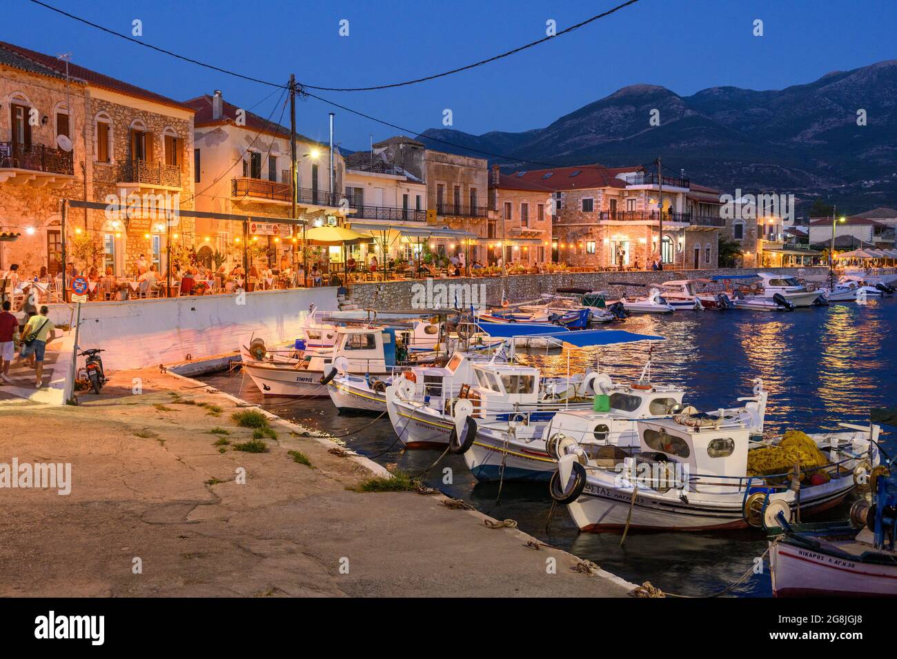 Guardando attraverso il porto nel piccolo villaggio di pescatori di Ayios Nikolaos su una notte d'estate. Nella parte esterna di Mani, sud del Peloponneso, della Grecia. Foto Stock