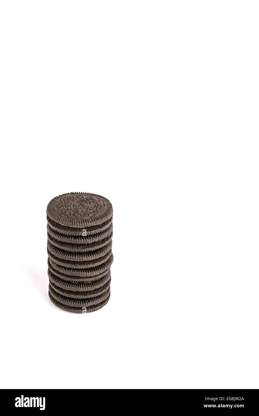 Biscotti e biscotti di cioccolato alla crema in pila e pezzi singoli isolati su sfondo bianco Foto Stock