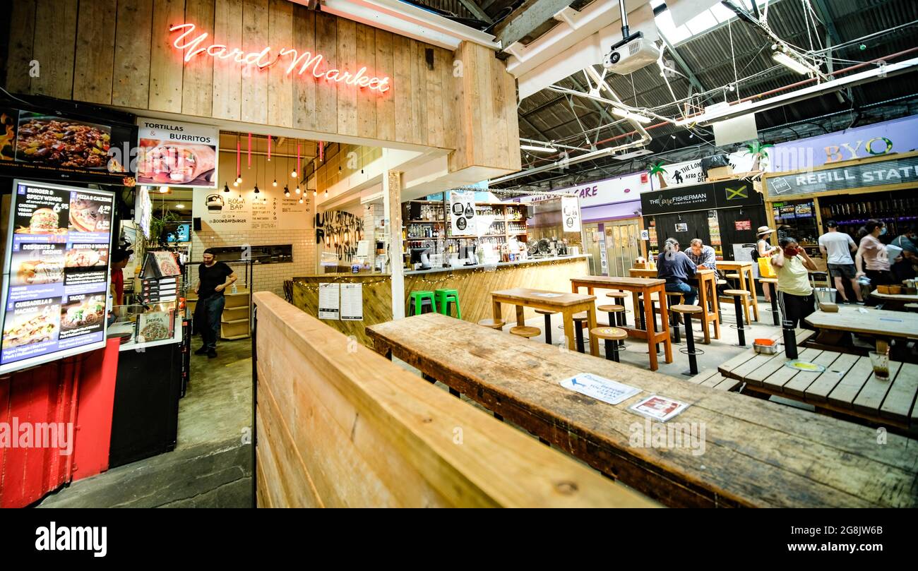 Londra- Luglio 2021: Tooting Market nel sud-ovest di Londra, un mercato al coperto con molti venditori e commercianti di cibo di strada Foto Stock Londra- Luglio 2021: Tooting Market nel sud-ovest di Londra, un mercato al coperto con molti venditori e commercianti di cibo di strada Foto Stock