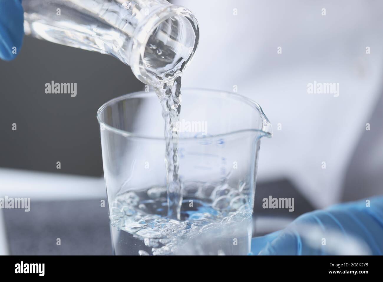 Lo scienziato esamina l'acqua potabile nella formazione del laboratorio Foto Stock