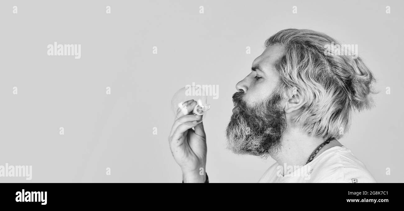 hipster felice di umore allegro. Caduta nell'infanzia. Sensazione di bambino e di bambino. Felicità reale. aprile stolta giorno. Uomo bearded soffiando bolle di sapone Foto Stock