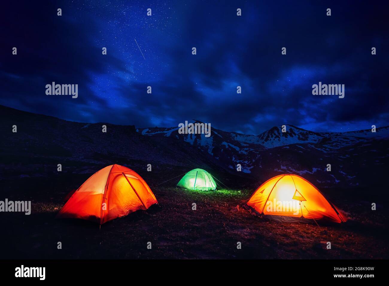 Giallo arancio e verde tenda da campeggio nella gola di montagna sotto il cielo notturno con stelle Foto Stock