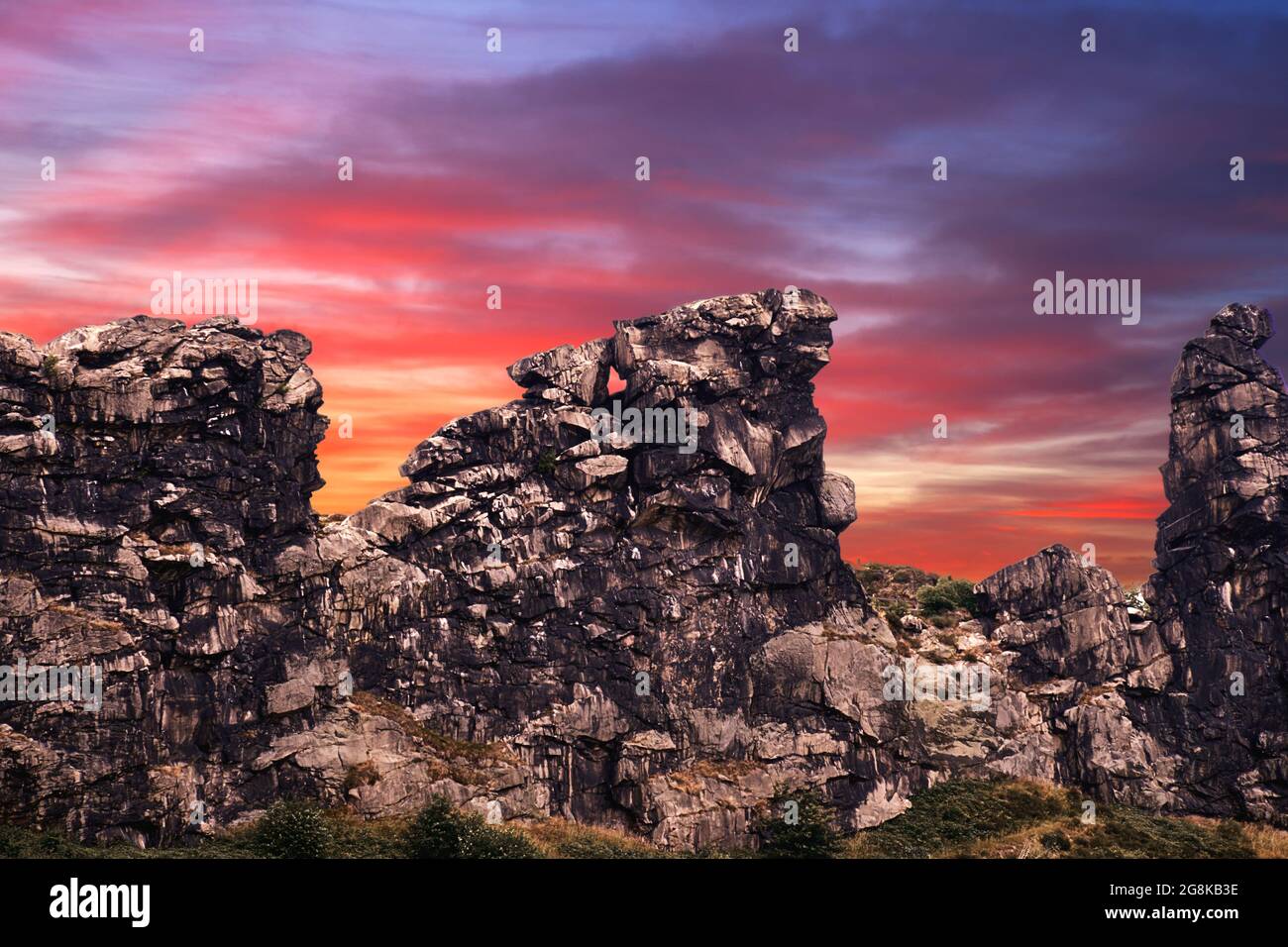 Composizione surrealistica del Muro del Diavolo nei pressi di Thale in Sassonia-Anhalt, Germania di fronte a un cielo serale rosso e viola, costolette di calcare sulla ed Foto Stock