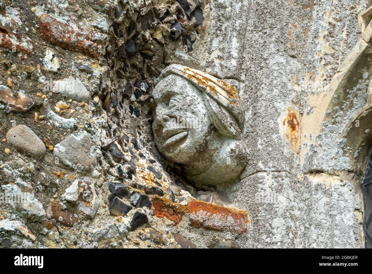 Testa scolpita che mostra la nicchia di selce rimossa nella parete di estensione successiva Chiesa di St Mary Dennington Suffolk UK Foto Stock