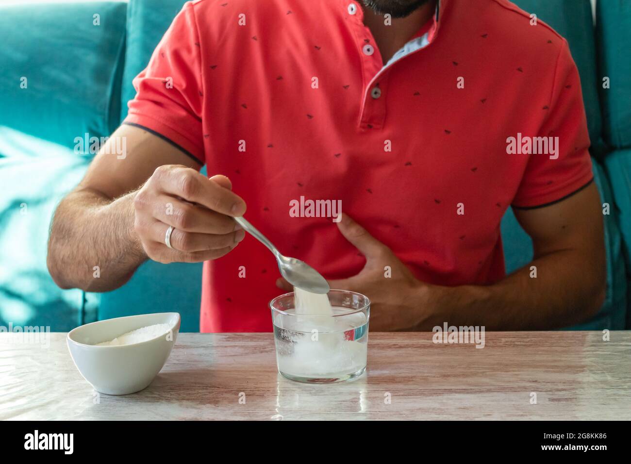 Uomo caucasico con mal di stomaco preparare sale di frutta Foto Stock
