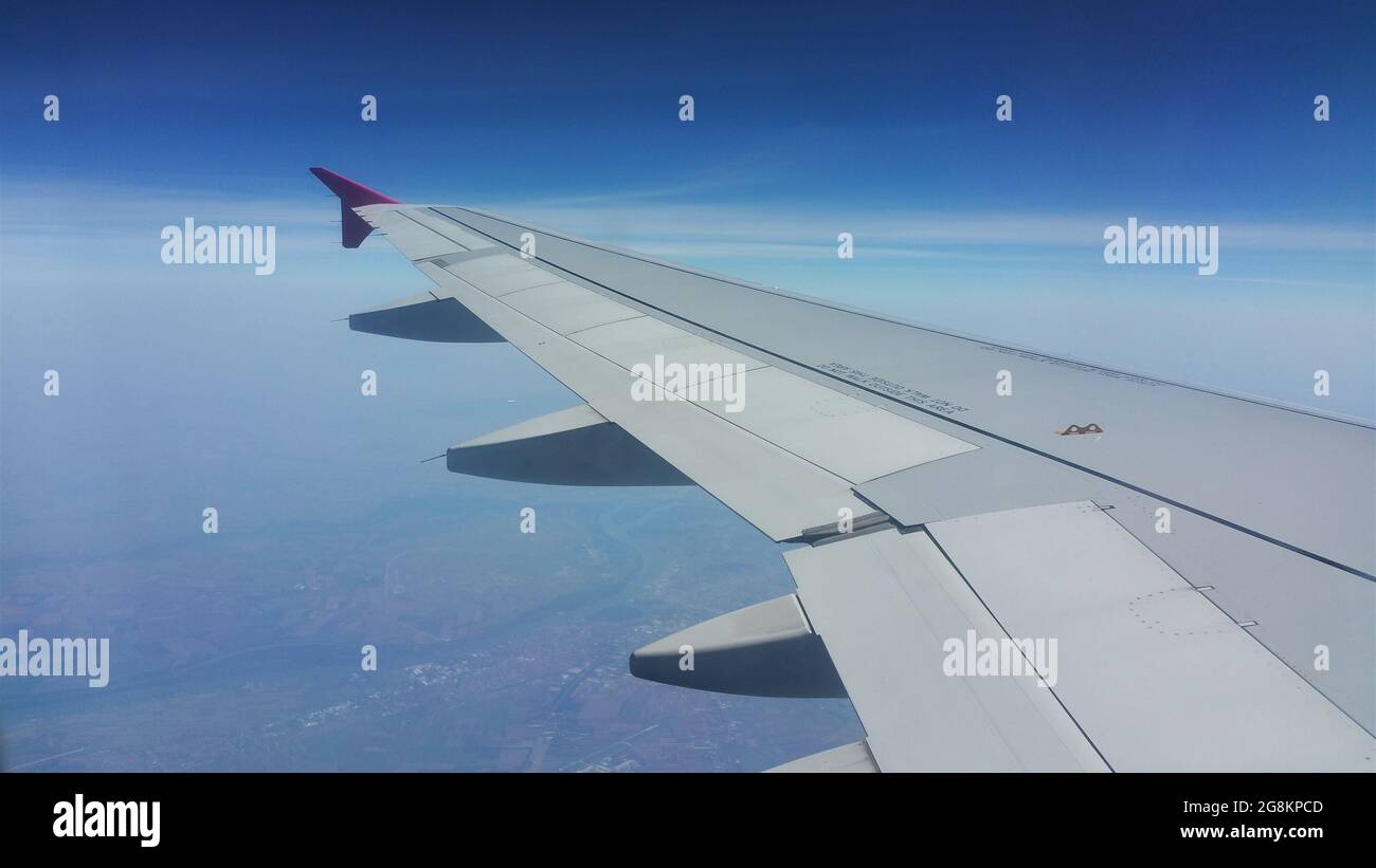 Closeup dell'ala di un aereo volante in una giornata di sole - perfetto per sfondi e sfondi Foto Stock