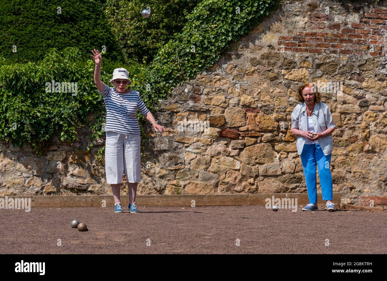Haddington, East Lothian, Scozia, Regno Unito, 21 luglio 2021. Sessione di coaching U3A Pétanque SPA: Colin (Monty) e Margaret (Mags) Montgomery, entrambi i pullman SPA (Scottish Pétanque Association) offrono una lezione al locale club di Pétanque dell'Università della 3a Età in uno dei giorni più caldi dell'anno nei giardini panoramici di Lady Kitty's Garden. Pétanque è una forma di boules, giocato con regole leggermente diverse Foto Stock