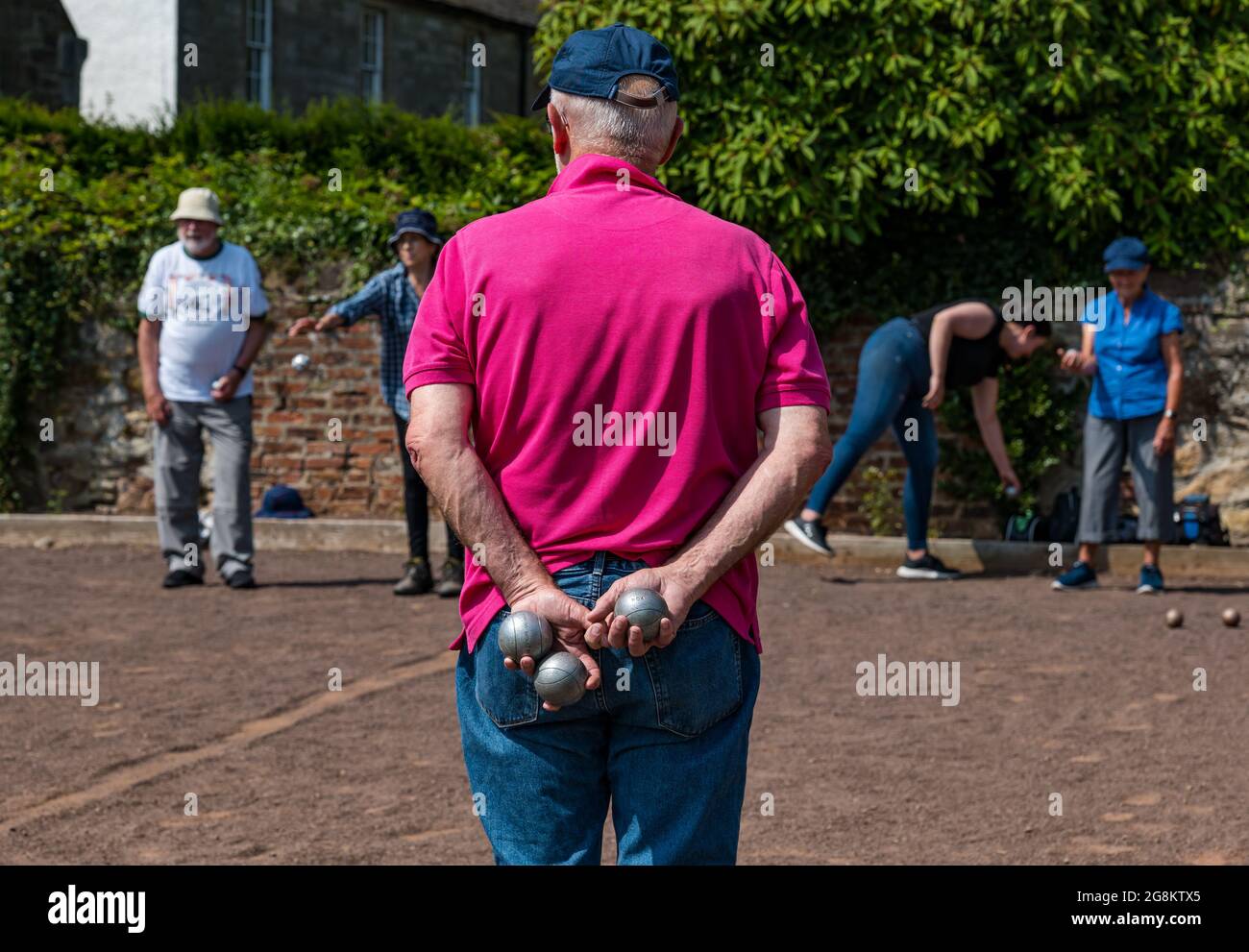 Haddington, East Lothian, Scozia, Regno Unito, 21 luglio 2021. Sessione di coaching U3A Pétanque SPA: Colin (Monty) e Margaret (Mags) Montgomery, entrambi i pullman SPA (Scottish Pétanque Association) offrono una lezione al locale club di Pétanque dell'Università della 3a Età in uno dei giorni più caldi dell'anno nei giardini panoramici di Lady Kitty's Garden. Pétanque è una forma di boules, giocato con regole leggermente diverse Foto Stock