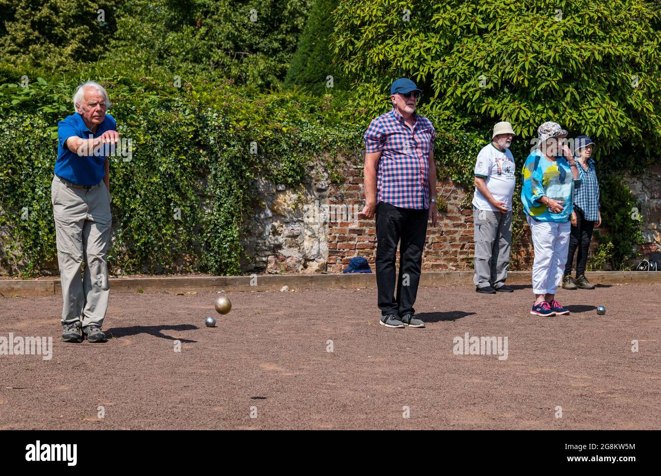 Haddington, East Lothian, Scozia, Regno Unito, 21 luglio 2021. Sessione di coaching U3A Pétanque SPA: Colin (Monty) e Margaret (Mags) Montgomery, entrambi i pullman SPA (Scottish Pétanque Association) offrono una lezione al locale club di Pétanque dell'Università della 3a Età in uno dei giorni più caldi dell'anno nei giardini panoramici di Lady Kitty's Garden. Pétanque è una forma di boules, giocato con regole leggermente diverse Foto Stock
